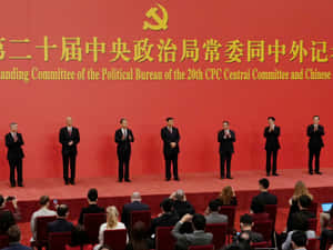 七名身穿西裝的官員在正式政治活動期間在紅色舞台上鼓掌。 — 唐人街 GIF 壁紙
