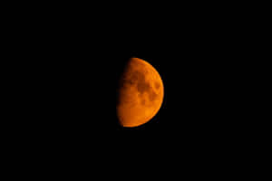 在黑暗夜空中發出橙色光芒的半月