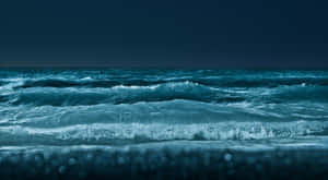 夜空下的海浪，散景燈光映照在濕沙上