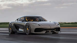 銀色 Koenigsegg Jesko 在潮濕的賽道上飛馳，帶有黃色點綴。