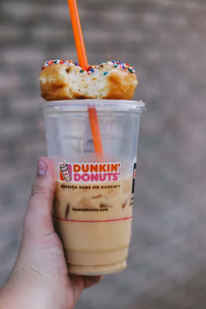 手拿著Dunkin' Donuts冰咖啡，上面有甜甜圈。 — 2:3 壁紙