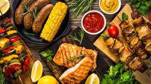 烤好的肉類、蔬菜和醬汁擺放在木板上，適合夏季燒烤。