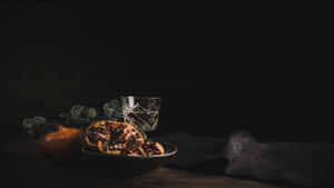碗中的切片石榴，旁邊有完整水果和玻璃杯，置於木桌上。