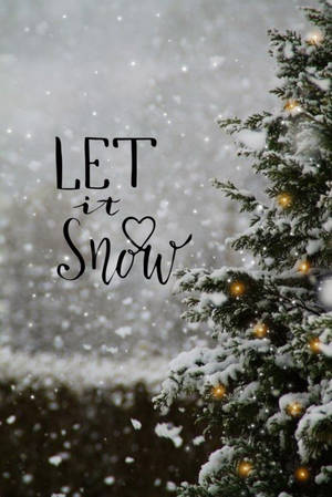 被雪覆蓋的松樹，帶有發光的燈光和「let it snow」文字。