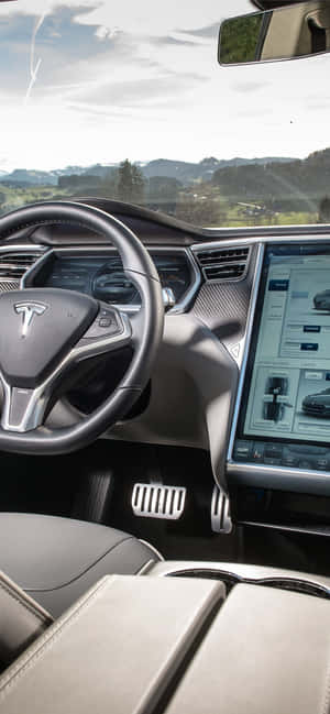 Tesla 車廂內部，配備數碼儀表板和擋風玻璃外的山景。 — iPhone 11 Pro 壁紙