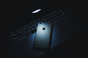 銀色iPhone在筆記型電腦鍵盤上，昏暗藍光