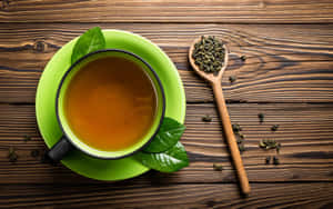 木桌上放著一杯帶有新鮮葉子的綠茶。