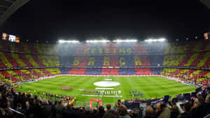 夜間足球場，球迷舉起紅、黃、藍色橫幅拼出 BARÇA。