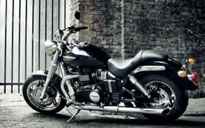 黑色 Triumph 電單車停泊喺磚牆旁邊，帶有金屬圍欄