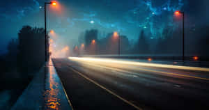 夜晚一條潮濕空曠的道路，有發光的街燈和星光藍色天空。