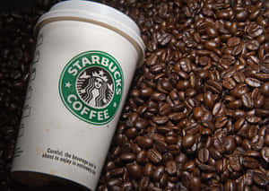 Starbucks咖啡杯被烘焙咖啡豆環繞。