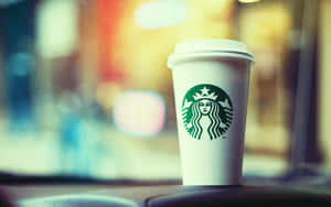 Starbucks咖啡杯放在汽車儀表板上，背景有城市燈光