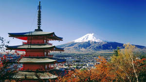 紅色寶塔，背景是富士山，周圍環繞著秋天的樹木和小鎮。