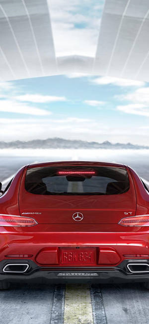 紅色 Mercedes-AMG GT 跑車在玻璃天篷下的道路上，有山脈和天空。