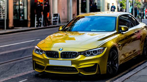 閃亮的金色BMW跑車停泊在城市的街道上，有行人。 — 黃色 壁紙