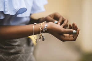 手腕特寫，帶有層疊手鍊和淺藍色指甲油。 — MacBook Pro 壁紙