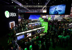 Xbox遊戲活動中的人群，配有發光綠色展位和屏幕。 — 遊戲 壁紙