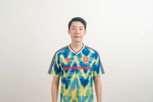 年輕男子身穿藍黃紮染足球球衣，帶紅色文字