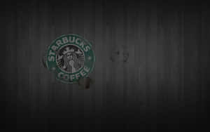 Starbucks標誌，深色木地板上有咖啡漬。