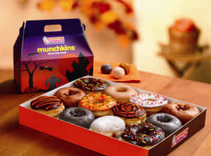 萬聖節主題的Dunkin' Donuts Munchkins冬甩盒，放在木桌上，有秋葉。