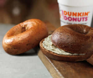 烤百吉餅配奶油芝士和Dunkin' Donuts咖啡杯在木板上。 — 早晨咖啡 壁紙