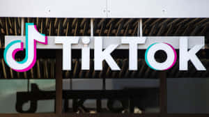建築物上的 TikTok 標誌招牌，帶有彩色音符和白色字母。 — TikTok GIF 壁紙