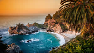熱帶海灘上的夕陽，有碧綠的海水和棕櫚樹。 — 馬里布 壁紙