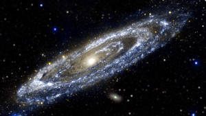 一個帶有明亮旋臂和散落恆星的螺旋星系。 — 星星 壁紙