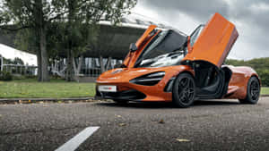 橙色McLaren 780S超級跑車車門打開，停泊在戶外，附近有樹木和建築物。