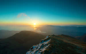 從結霜的山脊上看到的夕陽、山脈和大海