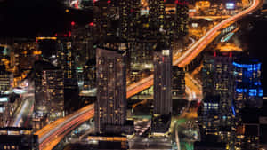 夜晚的城市，有明亮的塔樓和高速公路上流動的車燈。 — 風景動圖 壁紙