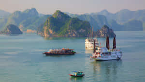 傳統船隻在日落時分的碧綠海灣中，於高聳的綠色島嶼之間平靜地漂浮。