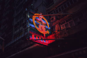 夜間城市建築物上帶有紅色和藍色發光字符的霓虹燈牌。