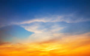 鮮豔的日落天空，帶有橙色和藍色色調以及薄雲。 — 藍天 壁紙