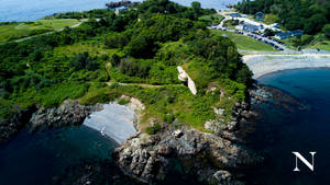 海岸半島，有綠色懸崖、岩石海岸和碧綠海水。