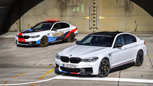 兩輛BMW M5汽車，一輛安全車，停放在混凝土隧道下。