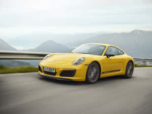 黃色保時捷911 Carrera T在山路上疾馳，呈現模糊動態。