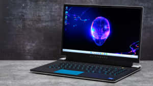Alienware 遊戲手提電腦，屏幕上帶有發光外星人牆紙。