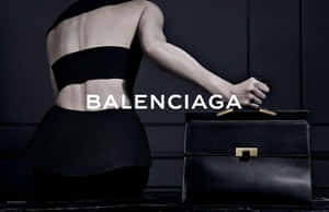 一位黑色時尚模特兒在昏暗的攝影棚中手持Balenciaga手袋。