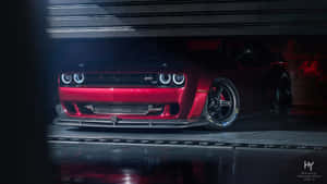 紅色 Dodge Challenger SRT Hellcat 在昏暗的車庫中，頭燈發光。