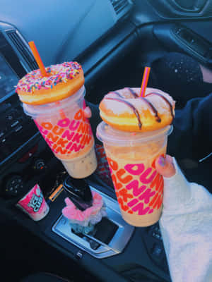 兩杯有冬甩配料嘅Dunkin'凍飲喺車入面，波棍上有個粉紅色頭箍。 — 早晨咖啡 壁紙