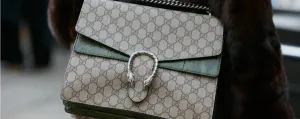 Gucci Dionysus手袋特寫,配有綠色蛇皮飾邊和銀色五金件,搭配毛皮大衣。
