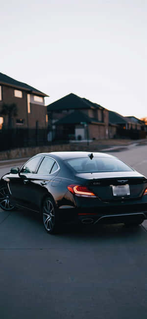 黑色Genesis G70房車停泊在住宅區街道上（黃昏）。