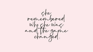 粉紅色背景上優雅的手寫名言，寫著「she remembered who she was and the game changed。」