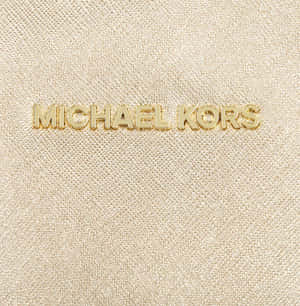 金色 Michael Kors 標誌在紋理米色布料上。