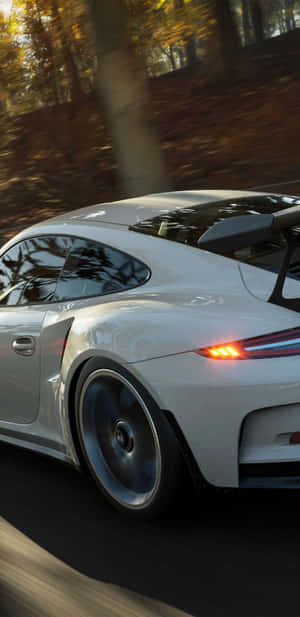 白色保時捷911 GT3 RS在日落時分於秋林中疾馳。 — Huawei Mate 70 Air 壁紙