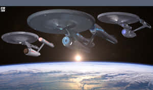 三艘星際迷航星艦在日落時飛越行星。 — 行星 壁紙