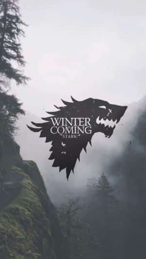 冰原狼徽章與「Winter is Coming」在霧氣瀰漫的山脈和樹木之上。