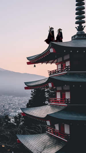 黃昏時分，兩個穿長袍的人物在日本寶塔上俯瞰山脈和城市。