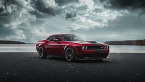 紅色Dodge Challenger停喺湖邊，天空風暴密佈。